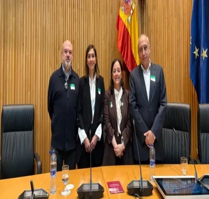 Todos los participantes de la ponencia en la sala del Congreso posando, frente a la bandera de España y de la UE