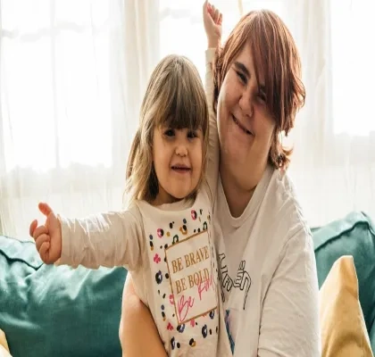 Una mare junto a su hija sentadas en el sofá