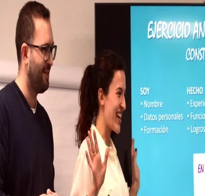 Dos personas haciendo una presentación delante de la pantalla digital