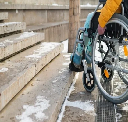 Persona con silla de ruedas ante unas escaleras