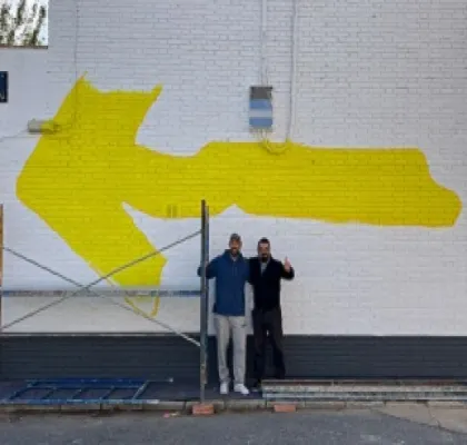 Momento del proceso de realización de la gran Flecha Amarilla del Camino de Santiago, con el grafitero Reyes19 y Antonio Tejada de La Ciudad Accesible (Fuente: La Ciudad Accesible)