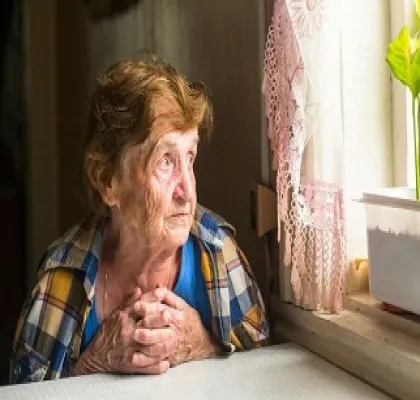 Una mujer mayor mirando sola por la ventana (Fuente: AvisoVoz)