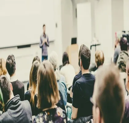 Profesor enseñando un temario en un aula con alumnos atendiendo