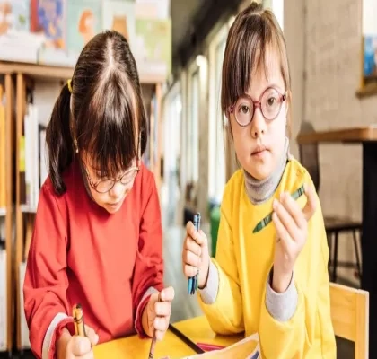 Dos niñas con síndrome de Down dibujan en un aula