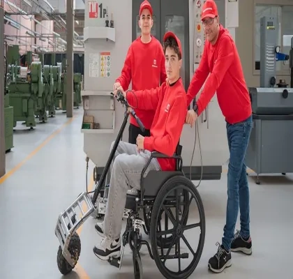 En la imagen se puede ver a los dos alumnos y al profesor, uno de ellos probando el proyecto en una silla de ruedas