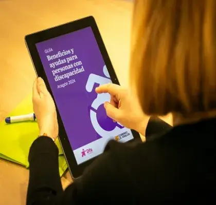 Una persona viendo online, en una tablet, la guía sobre beneficios y ayudas para personas con discapacidad de la Fundación Dfa (Fuente: Fundación Dfa)