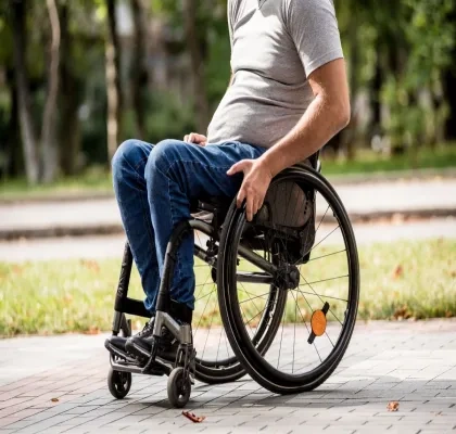 Un hombre en silla de ruedas cerca de un parque