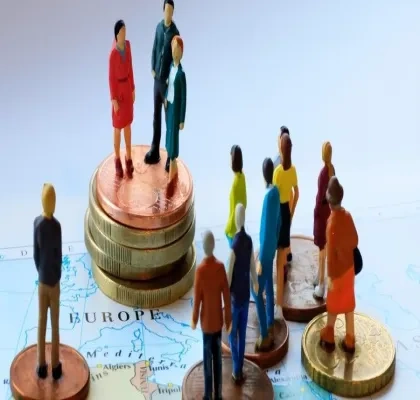 Muñecos subidos a monedas en una representación de la economía social