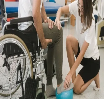 Fisioterapeuta con una persona con discapacidad realizando un tratamiento de rehabilitación