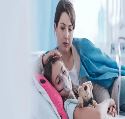 Madre cuidando a su hija con fibrosis quística que está en la cama usando un tratamiento respiratorio