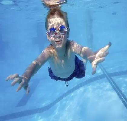 Un niño nadando debajo del agua de una piscina (Fuente: Clínica Baviera)