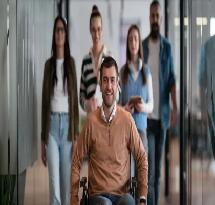 Una persona en silla de ruedas a compañada de otras personas