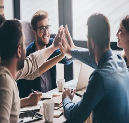 Grupo de jóvenes trabajando juntos y chocando sus manos (Fuente: Fundación Integra)
