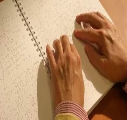 Detalle de una persona leyendo en braille