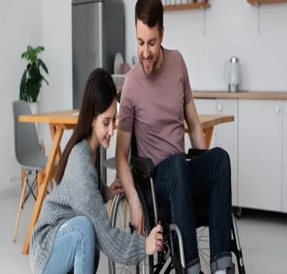 Mujer sin discapacidad ayudando a frenar la silla de un chico en silla de ruedas
