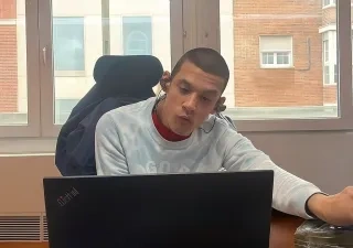 Kenjy trabajando en una oficina con su portatil