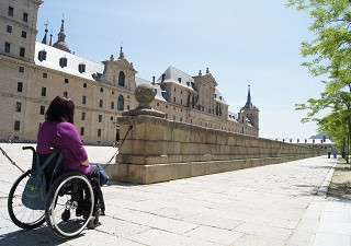 Mujer en silla de ruedas admirando el Escorial