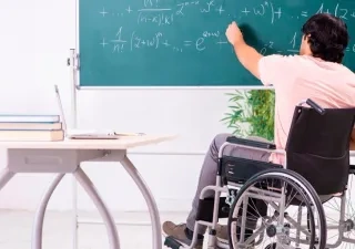Un profesor con discapacidad en silla de ruedas escribe en una pizarra | Foto de 123RF/Elnur