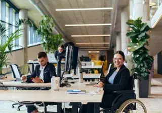 trabajadora con discapacidad física en silla de ruedas, durante su jornada laboral