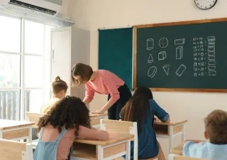Una profesora atiende a sus alumnos en clase