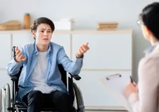 persona en silla de rueda hablando con un doctor