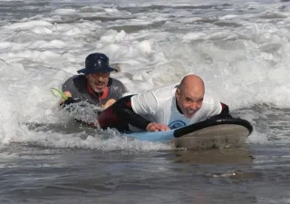 Niccolò Taverna en una sesión de surf terapeútico con un alumno