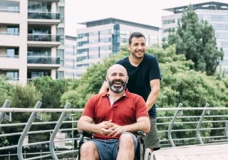 Imagen de un hombre en silla de ruedas acompañado durante un paseo