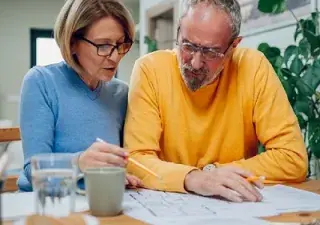 Dos personas mayores con riesgo de padecer algunas de las patologías propuestas debido a su edad, estudiando lo que les queda para su jubilación (Fuente: COCEMFE)