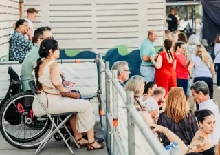 Una mujer en silla de ruedas en un lugar accesible de un evento