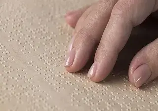 Mano de una persona leyendo un libro en braille (Servimedia)