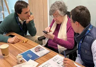 Voluntarios de Axis Corporate ayudando a una persona mayor en el Taller "Abuelos Hackers", para reducir la brecha digital (Fuente: Axis Corporate)