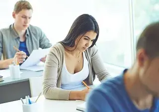 Una mujer junto a sus compañeros realizando una de las pruebas selectivas para empleo público (Fuente: Servimedia)