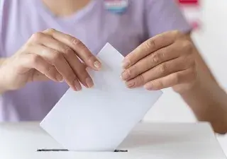 Una persona metiendo un sobre en una urna (Fuente: Servimedia)