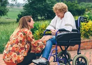 Una mujer en silla de ruedas, acompañada de otra (Fuente: Cermi)