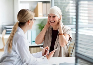 Una mujer bajo los efectos del tratamiento contra el cáncer de mama atendida por una profesional (Fuente: Doctoralia)