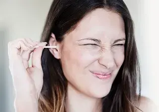 Una persona limpiándose el oído con un bastoncillo (Fuente: Oticon)