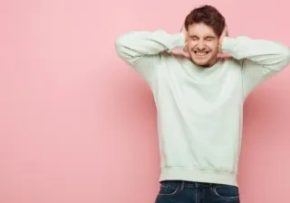 Hombre tapándose los oídos por el ruido tan molesto que escucha