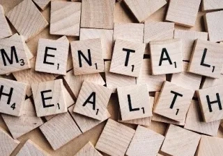 un dibujo de la salud mental con piezas de puzle,  que cada pieza contiene una letra