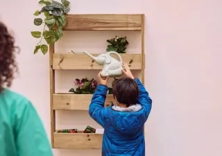 Imagen de un niñp intentando colgar un objeto en una estantería