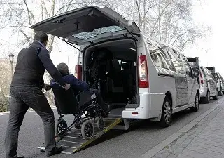 Una persona subiendo a un taxi adaptado para personas con movilidad reducida, ayudado por el propio taxista (Fuente: Gacetín Madrid)