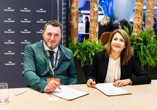 dos personas firmando el convenio