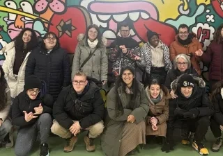 Los quince alumnos posando para una foto delante de un mural