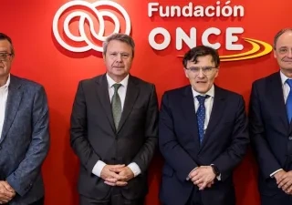 Los 4 representantes de la Fundacion ONCE posando delante del logo de la entidad 