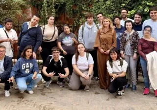 Los 15 alumnos posando en el jardín del campus para una foto grupal