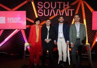 Los 4 participantes en la inauguración, subidos al escenario principal con el cartel del evento en la pantalla digital del fondo de la imagen