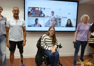Acto oficial de la primera convocatoria de la formación, aquí estan varios deportistas con discapacidad y justo detras una pizarra digital con gente en videollamada