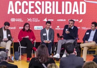 aparecen cinco personas hablando en una charla con un cartel detras que pone accesibilidad
