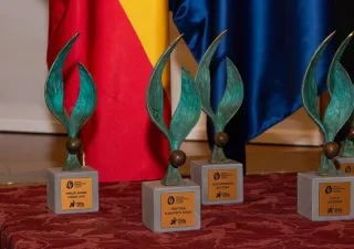 4 premios Zangalleta en la mesa, con bandera de España y Unión Europea de fondo 