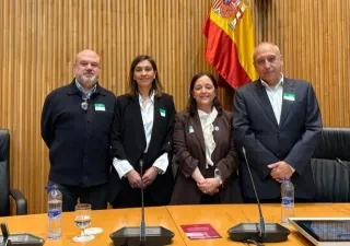 Todos los participantes de la ponencia en la sala del Congreso posando, frente a la bandera de España y de la UE