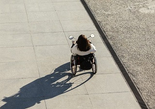 Una persona en silla de ruedas paseando por una calle (Fuente: Servimedia)